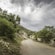 A dirt road on a mountainside with rustic buildings